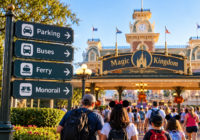 Guests approaching Magic Kingdom with signs for parking, buses, ferry and monorail, illustrating how long it takes to get from Disney transportation or parking into the parks.